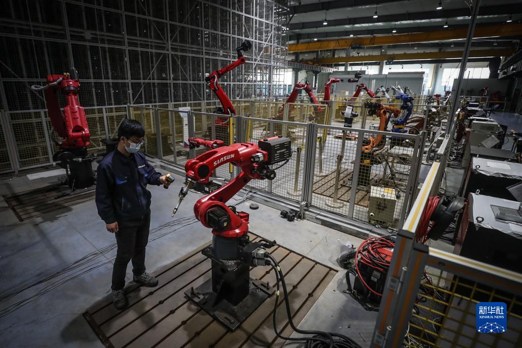 2022年4月28日，新松機(jī)器人自動化股份有限公司的工作人員在生產(chǎn)車間內(nèi)調(diào)試機(jī)器人。新華社記者 潘昱龍 攝