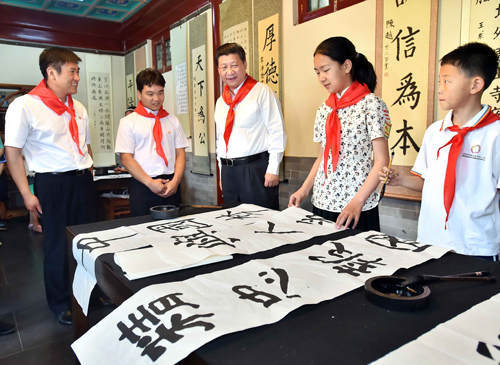 2014年5月30日上午，中共中央總書記、國家主席、中央軍委主席習近平來到北京市海淀區(qū)民族小學，參加慶?！傲弧眹H兒童節(jié)活動。這是習近平觀看學生書寫的毛筆字。新華社記者 李濤 攝