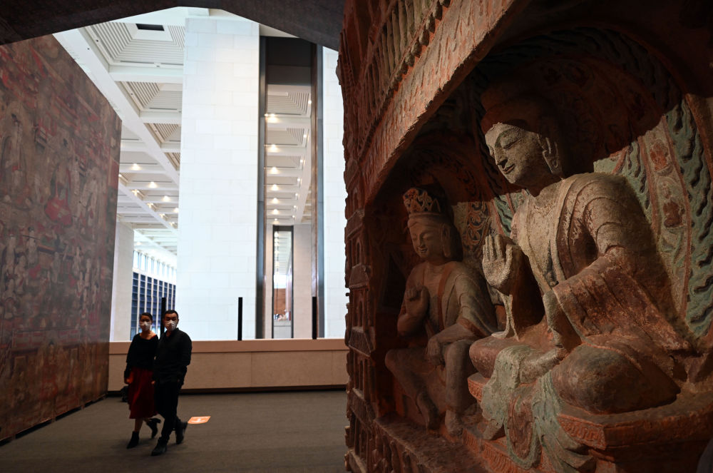 參觀者在中國(guó)國(guó)家博物館的“盛世修典——‘中國(guó)歷代繪畫大系’成果展”上觀看等比例高保真數(shù)字化3D打印復(fù)制的云岡石窟第6窟南壁“文殊問疾”屋形龕(2022年9月29日攝)。新華社記者 金良快 攝