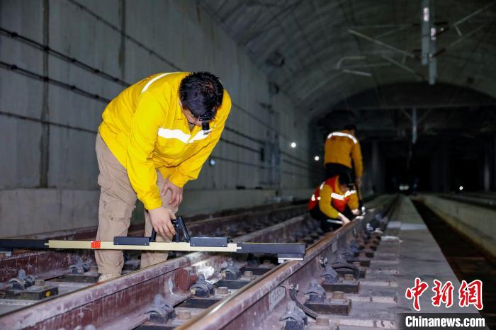 中國鐵路南寧局集團(tuán)有限公司南寧工務(wù)段職工使用道尺檢查吳圩機(jī)場高鐵站高鐵線路設(shè)備?！№f剛 攝
