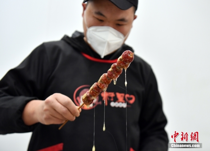 雄安新區(qū)大樹劉莊村辛愛(ài)青家中的冰糖葫蘆加工廠，工人正在制作冰糖葫蘆。作為遠(yuǎn)近聞名的“冰糖葫蘆村”，大樹劉莊村制作冰糖葫蘆的歷史已有100多年，全村三分之二的村民都會(huì)這門手藝，吸引不少游客慕名而來(lái)。 中新社記者 韓冰 攝