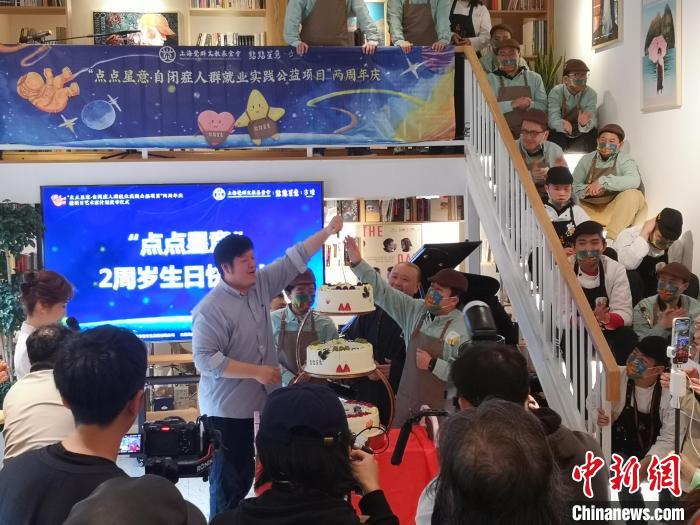 黃悅與自閉癥咖啡師共同切蛋糕，慶?！包c點星意”自閉癥人群就業(yè)實踐公益項目發(fā)起兩周年?！》队畋?攝